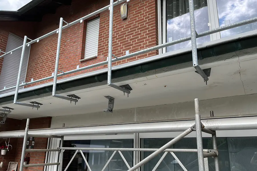 An der Außenfassade eines Backsteingebäudes ist ein Metallgerüst angebracht.